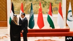FILE - China's Foreign Minister Wang Yi shakes hands with Saudi Arabia's Foreign Minister Prince Faisal bin Farhan Al-Saud at a meeting of foreign ministers from Arab and Muslim-majority nations at the Diaoyutai State Guest House in Beijing, Nov. 20, 2023. 
