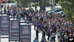 FILE - People line up outside McKale Memorial Center on the University of Arizona campus, Jan. 12, 2011, in Tucson, Ariz.