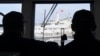 Philippine coast guard members observe a Chinese coast guard ship blocking their path during a re-supply mission by a civilian boat chartered by the Philippine navy to deliver supplies to a Philippine navy ship in the disputed South China Sea, Aug. 22, 2023.
