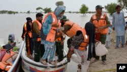Rescue workers evacuate villagers through a boat from a flooded area of Pakpattan district of Pakistan's Punjab province, Aug. 23, 2023. 