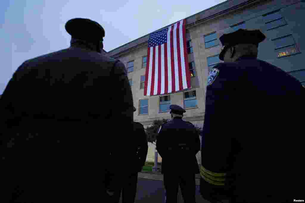 First responders watch as a U.S. flag is unfurled from the Pentagon roof to mark the 22nd anniversary of September 11, 2001 attacks, at the Pentagon in Washington.