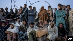 FILE - Afghan refugees wait to register in a camp near the Torkham Pakistan-Afghanistan border in Torkham, Afghanistan, Nov. 4, 2023.