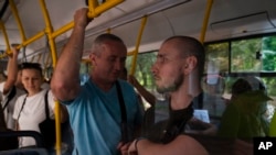 Oleksandr Zhylchenko, left, and Ivan Soroka, former Ukrainian soldiers blinded in the war, ride a bus as part of their training.