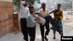 People carry a man wounded during a clash between supporters of Bangladesh Nationalist Party and police in Dhaka, Bangladesh, Oct. 28, 2023.