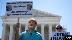People hold anti-Trump signs in front of the U.S. Supreme Court on July 1, 2024, in Washington after the court ruled that presidents have presumptive immunity for official acts.