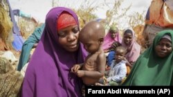 ARCHIVO - Nunay Mohamed, de 25 años, que huyó del área de Lower Shabelle afectada por la sequía, sostiene a su hijo desnutrido de un año en un campamento improvisado para desplazados en las afueras de Mogadiscio, Somalia, en junio de 2022.
