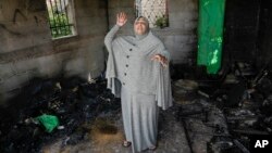 A Palestinian woman reacts to damage done to her house in Qusra, near Nablus, West Bank, April 14, 2024. Israeli settlers in the occupied West Bank had gone on an extensive rampage in the area; witnesses said settlers assaulted a number of communities.