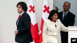 Georgian President Salome Zourabichvili, right, and Prime Minister Irakli Kobakhidze, left, leave a podium after marking Independence Day in Tbilisi, Georgia, May 26, 2024.