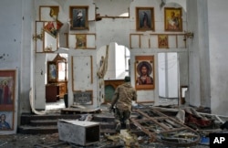 A Ukrainian serviceman kneels in a church damaged in a Russian air raid of the town of Orikhiv in the Zaporizhzhia region, Ukraine, April 5, 2024.