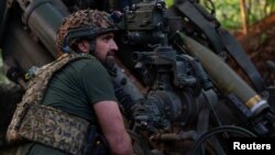 একজন ইউক্রেনীয় সেনা ডনেটস্ক অঞ্চলে ফ্রন্ট লাইনের কাছে রুশ সেনাদের লক্ষ্য করে হাউইটজার নিক্ষেপের প্রস্তুতি নিচ্ছেন। ১ মে, ২০২৪।