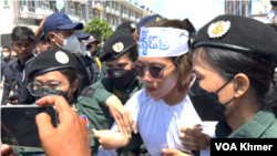 រូបឯកសារ៖ អាជ្ញាធរ​កំពុង​ក្រៀកកញ្ញា​ ឡុង គន្ធា សកម្មជន​ចលនា​មាតា​ធម្មជាតិ​បញ្ជូន​ចូល​រថយន្ត នៅ​ថ្ងៃទី​២ ខែកក្កដា ឆ្នាំ២០២៤។ (កាន់ វិច្ឆិកា/វីអូអេ)