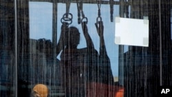 An evacuee from Sudan sits in a shuttle bus after arriving with a British military transport aircraft at Larnaca airport, Cyprus, April 27, 2023.