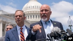 Republican Representatives Scott Perry, left, and Chip Roy, members of the conservative House Freedom Caucus, discuss the debt limit deal during a news conference on Capitol Hill in Washington, May 30, 2023.
