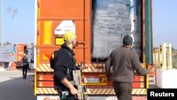 FILE - A humanitarian aid truck is inspected at the Kerem Shalom crossing, on the border between Israel, Gaza and Egypt, in this still image taken from video released Dec. 12, 2023. (COGAT via X/Handout via Reuters)