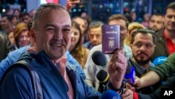 A passenger who arrived on a flight from Vienna shows his passport after being one of the first people to take advantage of Romania's entry in the Schengen Area, at Henri Coanda International Airport, near Bucharest, March 31, 2024.