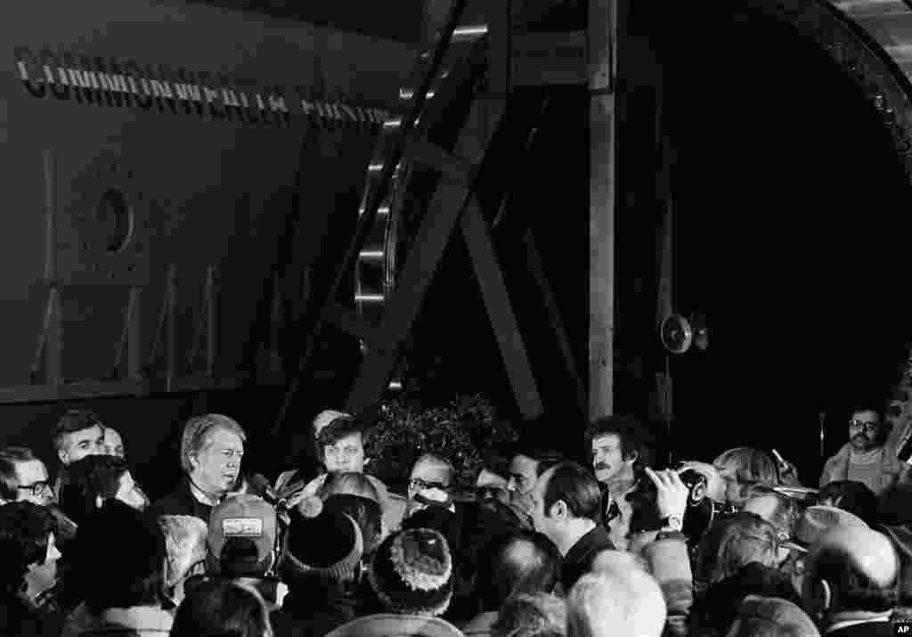 President Jimmy Carter, left, is dwarfed by a turbo generator at the Westinghouse Corp. plant, east of Pittsburgh, Pennsylvania, Jan. 30, 1977 where he went to emphasize the serious fuel shortage.