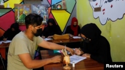 Khushi talks to her art teacher Zaheen in an art studio in Mazar-i-Sharif, Afghanistan, August 6, 2023. (REUTERS/Ali Khara)