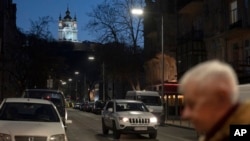 A man walks with the St. Andrew's Church on the background in Podil district in Kyiv, Ukraine, March 18, 2023. 