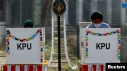 Pemilih turut berpartisipasi dalam Pilkada 2020 dengan mencoblos surat suara mereka di TPS di Tangerang, 9 Desember 2020. (Foto: REUTERS/Willy Kurniawan)