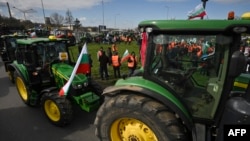 FILE - Farmers drive tractors during an action to block trucks crossing the Danube bridge, marking the border between Bulgaria and Romania, in a protest against the duty-free import of grain coming from Ukraine into the EU, in Rousse on March 29, 2023.