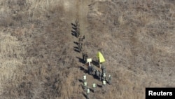 FILE - North Korean army soldiers, top, head to cross the Military Demarcation Line inside the Demilitarized Zone (DMZ) to inspect the dismantled South Korean guard post, Dec. 12, 2018.