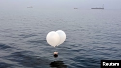 A balloon carrying various objects including what appeared to be trash, believed to have been sent by North Korea, is pictured at the sea off Incheon, South Korea, June 9, 2024. 