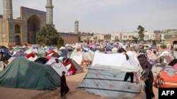 People walk past their makeshift shelters set up after an earthquake, in front of the Jami Mosque in Herat, Oct. 17, 2023. 