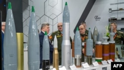 Belarusian military officers view heavy rounds on display at the Russian pavilion during the International Defense Exhibition (IDEX) at the Abu Dhabi International Exhibition Centre, Feb. 20, 2023. 