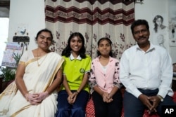 Gautam Dongre sits with his daughters, Sumedha, 13, second right, a patient of sickle cell disease, and Rushali, 15, and his wife, Padmashri, in Nagpur, India, Wednesday, Dec. 6, 2023. (AP Photo/Ajit Solanki)