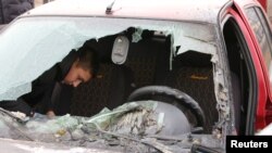 ফাইল ছবি - রাশিয়ার বেলগরদ অঞ্চলের রাজুমনো বসতিতে গোলাবর্ষণে আঘাতপ্রাপ্ত একটি ক্ষতিগ্রস্ত গাড়ি পরিদর্শন করছেন একজন স্থানীয় বাসিন্দা। (১৯ মার্চ, ২০২৪)
