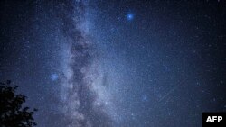 FILE - Shooting stars streak across the Milky Way during the 'Nuits des étoiles' (Starry Night), a major annual celebration for astronomy enthusiasts, in Fontainebleau, southern Paris, France, Aug. 13, 2023.