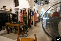 Floriana Peroni walks in her vintage clothing store in downtown Rome, that was forced to shut down for a week by a truck of rented generators blocking her door, in Rome, July 25, 2023.