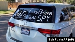 Sebuah mobil van yang terparkir di luar rumah Bob Fu di Midland, Texas, saat musim gugur 2020 dicoreti dengan tetulisan yang menuduh pendeta Kristen, warga AS keturunan Tionghoa itu, sebagai mata-mata Partai Komunis China.