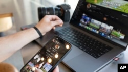 Adam Botkin, a football TikTok influencer, edits a video for a post in Missoula, Mont., May 3, 2023. Botkin gained notice on the social media platform after videos of him performing kicking tricks went viral. 