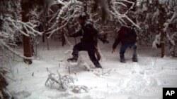 FILE - This surveillance image shows two individuals illegally crossing the U.S.-Canada border in January 2023 at the Vermont-New Hampshire-New York enforcement sector. Federal authorities have added 25 border patrol agents at a section of the northeastern U.S. border with Quebec in response to a spike in illegal crossings. The team started March 6, 2023.