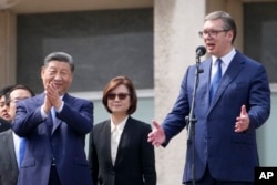 Chinese President Xi Jinping, left, and his Serbian counterpart, Aleksandar Vucic, greet the crowd at the Serbia Palace in Belgrade, May 8, 2024.
