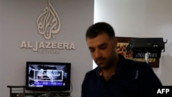 FILE - An employee of Qatar-based news channel Al Jazeera is seen at the media outlet's offices in Jerusalem, July 31, 2017.