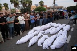 Palestinians pray for their relatives killed in the Israeli bombardment of the Gaza Strip in Deir al Balah, Oct.27, 2023.