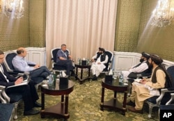 In this photo released by the Taliban Spokesman Office, Zabihullah Mujahid, chief spokesman for the Taliban and head of its delegation, center-right, speaks with Russian envoy to Afghanistan Zamir Kabulov, during a meeting in Doha, Qatar, June 30, 2024.