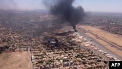This image grab taken from AFPTV video footage on April 20, 2023, shows an aerial view of black smoke rising above the Khartoum International Airport amid ongoing battles between the forces of two rival generals.