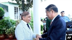 In this handout photo released by Pakistan Prime Minister's Office, Pakistan's Prime Minister Shehbaz Sharif, left, greets Chinese Vice Premier He Lifeng in Islamabad, Pakistan, on July 31, 2023.