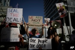 Families and supporters of Israeli hostages held by Hamas in Gaza hold banners and flags during a protest calling for their return, outside meetings of U.S. Secretary of State Antony Blinken in Tel Aviv, Israel, June 11, 2024.