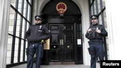 FILE - Policemen stand guard outside China's Embassy in London, Britain, Oct. 18, 2015. A statement issued Sunday by the diplomatic mission called a visit by British lawmakers, planned for Monday, a "gross interference in China's internal affairs."