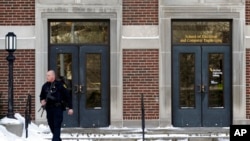 A police officer walks out of the electrical engineering building on the campus of Purdue University in West Lafayette, Ind., Jan. 21, 2014.