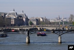 Kapal tongkang menyusuri Sungai Seine di Paris, Rabu, 5 April 2023. (Foto: AP)