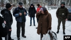 A woman receives food from local volunteers in Chasiv Yar, Feb. 14, 2023.