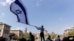 Columbia University sophomore David Lederer waves a large flag of Israel outside the student protest encampment on the campus, April 29, 2024, in New York.