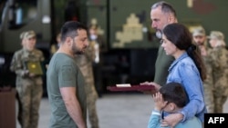 Ukraine President Volodymyr Zelenskyy presents a Gold Star Order to the wife of Lieutenant Colonel Oleh Babiy, who was posthumously named a Hero of Ukraine, during a meeting with defense intelligence officials, Sept. 7, 2023. (Ukrainian Presidential Press Service) 