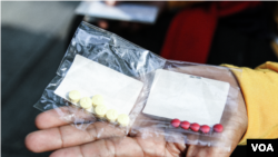 រូបឯកសារ៖ ស្ត្រីម្នាក់បង្ហាញកញ្ចប់ថ្នាំពីរថង់ នៅរាជធានីភ្នំពេញ កាលពីថ្ងៃទី ១ ខែមីនា ឆ្នាំ២០២៣។ (ទែន សុខស្រីនិត/វីអូអេ)