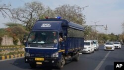 Security vehicles escort a police van carrying Arvind Kejriwal, leader of the Aam Admi Party, or Common Man's Party, to Tihar prison from a local court, in New Delhi, India, April 1, 2024. 